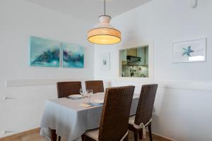 een eetkamer met een tafel met stoelen en een lamp bij Vistalmar in Altea