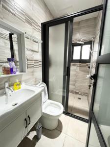 a bathroom with a toilet and a sink and a shower at Jod & Naic Appartement in Abidjan