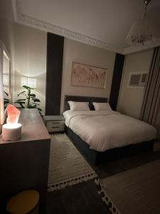 a bedroom with two beds and a table with a lamp at CRAFT LOFT - Amber 232 in Jeddah +6 photos