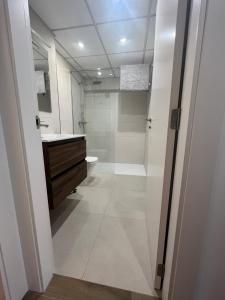 a bathroom with a shower and a sink and a toilet at Moderno apartamento centrico con piscina y parking in Denia