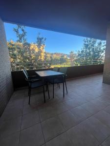 a table and chairs in a room with a large window at Moderno apartamento centrico con piscina y parking in Denia
