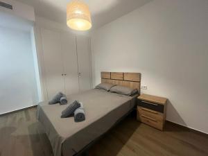 a bedroom with a bed and a night stand at Moderno apartamento centrico con piscina y parking in Denia +26 photos
