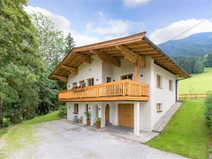duży biały dom z drewnianym balkonem w obiekcie Chalet Achenberg w mieście Brixen im Thale