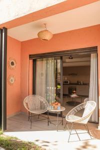 a patio with wicker chairs and a table on a patio at Maeva cosy - Clim, Wifi, Jardin à 10min de l'Aéroport in Marrakech