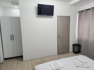 a white room with a flat screen tv on the wall at Casa Lupeni in Lupeni