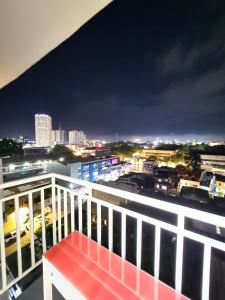 a red bench sitting on top of a balcony at night at MesaCondo Studio with Balcony in Davao City