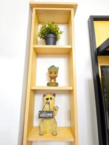 a book shelf with a pug and a welcome sign at MesaCondo Studio with Balcony in Davao City