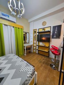 a living room with a bed and a tv and a room with at MesaCondo Studio with Balcony in Davao City +8 photos