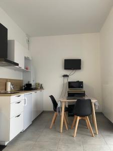 a kitchen with a table and chairs in a room at Gîte chti picard parking privé gratuit ,wifi et 100m de la plage in Berck-sur-Mer