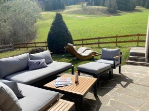 patio z kanapą, 2 krzesłami i stołem w obiekcie Chalet Achenberg w mieście Brixen im Thale
