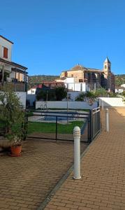 una recinzione nera su un patio in mattoni con edifici di El Rincón del Mirador a El Castillo de las Guardas