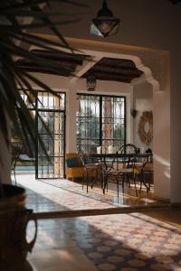 a dining room with a table and chairs and windows at La Vida Surf - Yoga Villa in Ounara