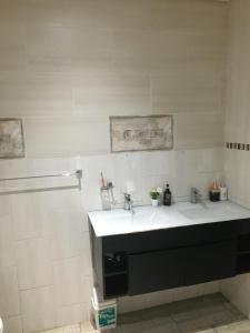 a white bathroom with a sink and a shower at Thornville Guesthouse Gold in Pietermaritzburg