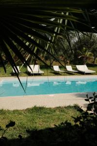 a swimming pool with two lounge chairs next to it at La Vida Surf - Yoga Villa in Ounara