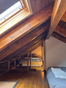 two beds in a room with wooden ceilings at Lo somni del riu in Llavorsí +2 photos