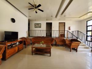 a living room with a couch and a tv at Ricardo Valley Inn in Coron