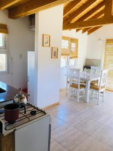 eine Küche mit Herd oberer Ofen neben einem Tisch in der Unterkunft Casita San Martín in San Martín de los Andes