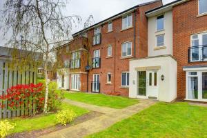 a brick apartment building with a garden in front of it at 2-BR Apartment, En-suite, Allocated Parking, next to Playground in Coventry