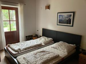 two beds sitting in a room with a window at Oleiro de Cima in São Teotónio