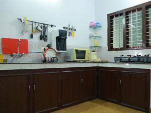 a kitchen with wooden cabinets and a counter top at karimeen hut in Irimbranallūr