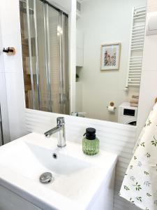 a white bathroom with a sink and a mirror at Apartamenty Prestige Harmony Rosiczkowa in Augustów