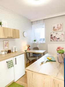 a kitchen with a counter and a table in it at Apartamenty Prestige Harmony Rosiczkowa in Augustów