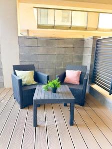 a patio with two chairs and a coffee table at Apartamenty Prestige Harmony Rosiczkowa in Augustów