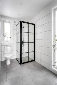 a bathroom with a toilet and a glass door at 2x Lake House's-Hot Tub-Stunning View-Private Pier in Smidö +78 photos
