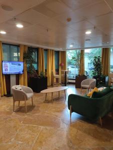 vestíbulo con sofás, mesa y TV en La Défense, Cozy Appartment 2 rooms, en Courbevoie