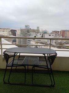 Una mesa en un balcón con vista a una ciudad. en La Défense, Cozy Appartment 2 rooms, en Courbevoie