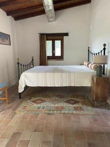 sypialnia z dużym łóżkiem z dywanem w obiekcie Umbrian cottage retreat w mieście San Giovanni del Pantano