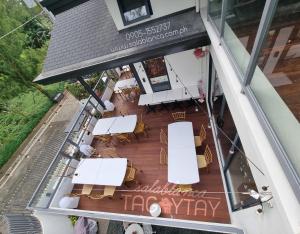 une vue aérienne d'un restaurant avec des tables et des chaises blanches dans l'établissement Salablanca Brand New Jacuzzi Heated Pool PS5 VR Cinema Fully AC Indoors Smart TVs with Netflix Disney Plus Large Balcony, à Tagaytay