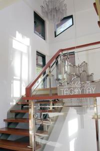 - un escalier dans une maison dotée d'un lustre dans l'établissement Salablanca Brand New Jacuzzi Heated Pool PS5 VR Cinema Fully AC Indoors Smart TVs with Netflix Disney Plus Large Balcony, à Tagaytay
