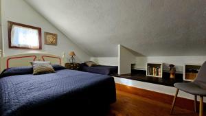 a bedroom with a bed and a chair in a attic at Cal Brugués - Casa de montanya in Ribes de Freser