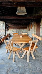 a wooden table and chairs in front of a building at Cal Brugués - Casa de montanya in Ribes de Freser