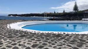 a large swimming pool sitting next to the water at Casa 3 Picos 1 in São Roque do Pico