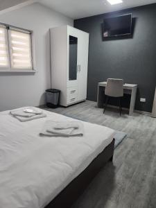 a bedroom with a bed with a desk and a chair at Casa Lupeni in Lupeni