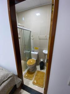 Un baño con inodoro y ducha de cristal. en Recando Dourado Suíte 4, en São Miguel dos Milagres