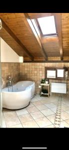 d'une grande salle de bains avec une grande baignoire et une lucarne. dans l'établissement Lejlighed i Bassola med privat parkering, à Armeno