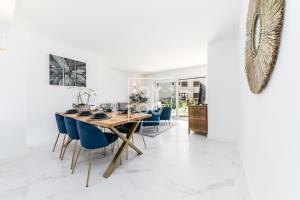 une salle à manger avec une table en bois et des chaises bleues dans l'établissement Infinity Blue Luxury Flat by OYOOSTAYS, à Torrevieja