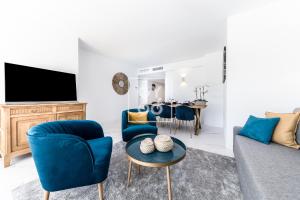 un salon avec un canapé, des chaises et une table dans l'établissement Infinity Blue Luxury Flat by OYOOSTAYS, à Torrevieja