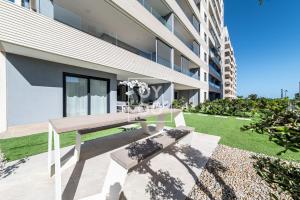 un banc en bois devant un bâtiment dans l'établissement Infinity Blue Luxury Flat by OYOOSTAYS, à Torrevieja