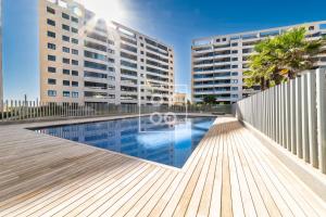 une piscine devant deux grands immeubles dans l'établissement Infinity Blue Luxury Flat by OYOOSTAYS, à Torrevieja