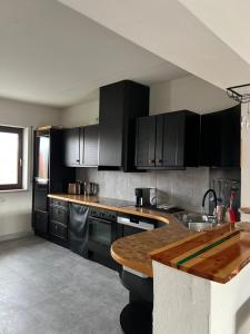 a kitchen with black cabinets and a wooden counter top at HandwerkerResidenz Roßtal in Roßtal
