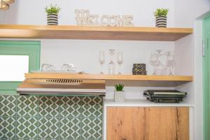una cocina con fogones y algunos vasos y estanterías en Urban Oasis Suite, en Ermoupoli 20 fotos más