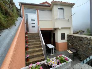 a house with stairs and flowers in front of it at Casa da Greta in Parada del Monte