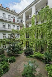 an ivy covered building with a courtyard at Near City park only 5 minutes walk , where you can find the world famous Szechenyi thermal bath spa, Capital Circus , Museums The apartment is modern and newly renovated ,in a quiet and peaceful green Oasis with AC ,smart TV, high speed internet in Budapest