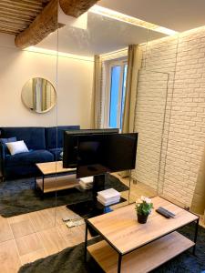 a living room with a blue couch and a television at Antibes Old Town Haven in Antibes