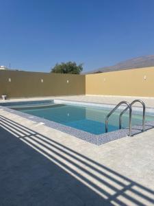 a swimming pool with stairs in a building at نزل نسيم الحمراء - nseem alhamra inn in Al Ḩamrāʼ
