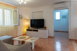 a living room with a couch and a flat screen tv at Apartman Domenika in Makarska